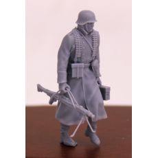 Voják Wehrmachtu kráčící v zimním kabátě s ocelovou helmou, kulometem MG 42 a bednou s kulometem